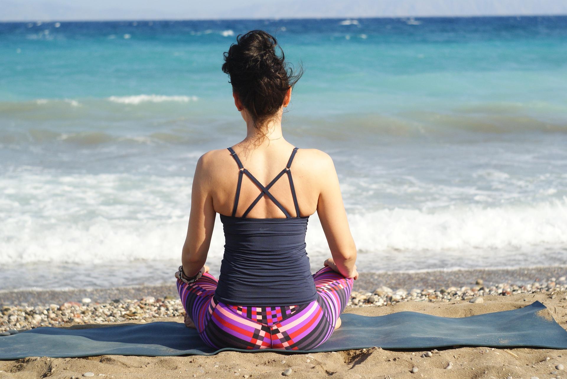 Dame på yogamatte med yoga håndkle