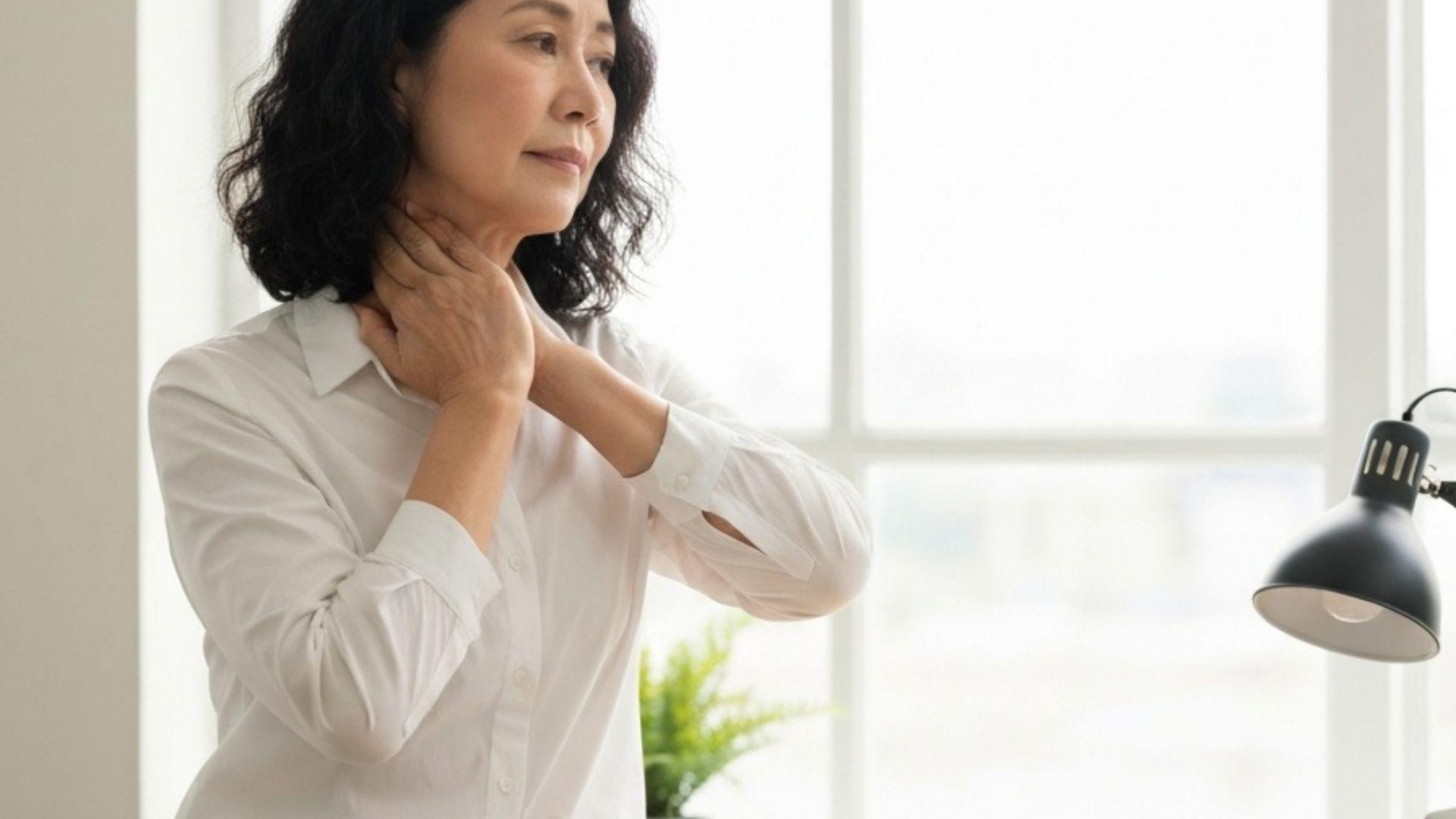 Kvinne tøyer nakken forsiktig på kontoret